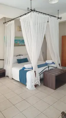 a bedroom with a bed with white drapes at Villa Di Gio in Paralimni