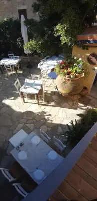 a patio with chairs and tables and tables and chairs at Ble Mavi - Studio for 2 in Vouni