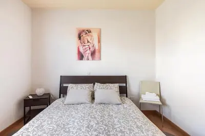a bedroom with a bed and a painting on the wall at Warm Residence in the heart of the City Center - Balcony & view in Nicosia
