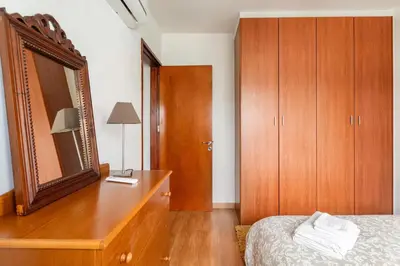a bedroom with a dresser with a mirror and a bed at Warm Residence in the heart of the City Center - Balcony & view in Nicosia