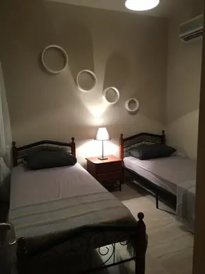 a bedroom with two beds and a table with a lamp at Ocean View sunny retreat in Protaras