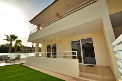 a balcony of a house with a lawn at Nissi Martha Apartment in Ayia Napa