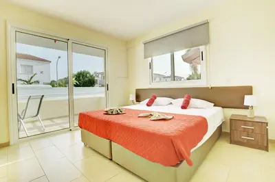 a bedroom with a bed and a balcony at Nissi Martha Apartment in Ayia Napa