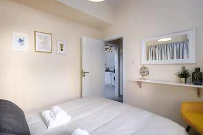 a bedroom with a white bed and a yellow chair at The Joy - Centre One Bedroom Flat in Larnaka