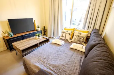 a living room with a couch and a flat screen tv at The Joy - Centre One Bedroom Flat in Larnaka
