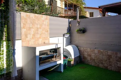 a small backyard with a fence and green grass at Demetris apartment in Meneou