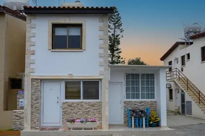 a white house with two chairs in front of it at Demetris apartment in Meneou