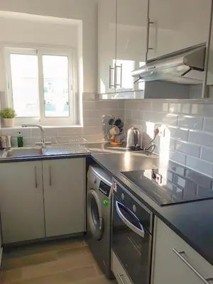a kitchen with a sink and a washing machine at Thalassa Sea View Suite in Limassol