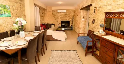a dining room with a table and a living room at Salamiou Stone House in Paphos City