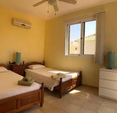 a bedroom with two beds and a window at Villa Lola in Ayia Napa