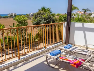 a balcony with a chair and towels and a view of the ocean at Angel Villa in Ayia Napa