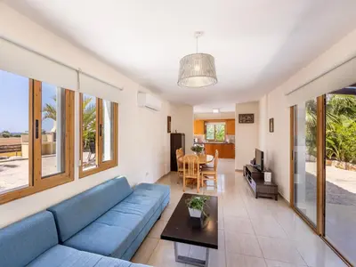 a living room with a blue couch and a table at Angel Villa in Ayia Napa