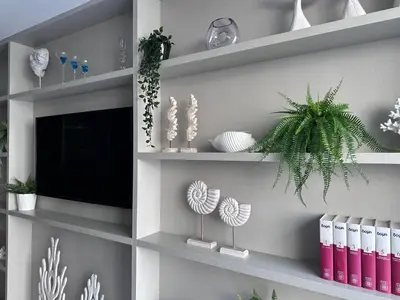 a room with shelves with plants and a tv at Levante Holiday Apartments in Larnaka
