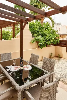 a table and chairs on a patio with a pergola at Kyklades Angie Resort in Protaras