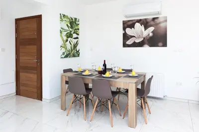 a dining room with a wooden table and chairs at Villa Rubi in Ayia Napa
