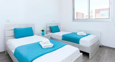 two beds in a room with blue and white at Villa Rubi in Ayia Napa