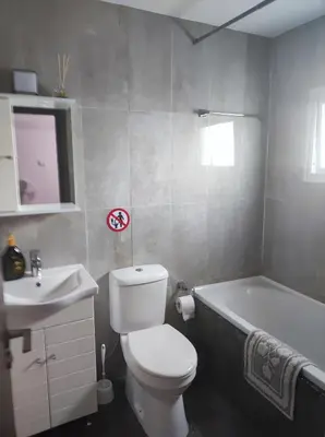 a bathroom with a toilet and a tub and a sink at Hawaii Royal Gardens in Limassol