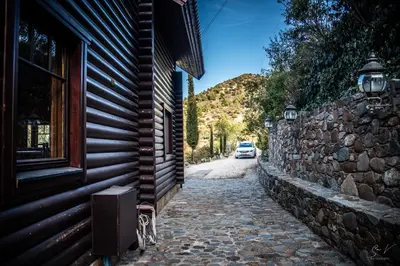 a car is parked on a street next to a building at *2 bdr log house /mountains/Queen bed/fireplace in Gourri