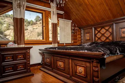 a bedroom with a wooden bed and a window at *2 bdr log house /mountains/Queen bed/fireplace in Gourri