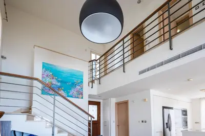 a staircase in a house with a large pendant light at AAA SEAVIEW PANORAMA in Pervolia