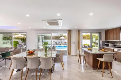 a kitchen and dining room with a table and chairs at Fig Tree Bay Residences 3-Jacuzzi-Hotub -Pool in Protaras