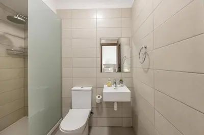 a white bathroom with a toilet and a sink at Fig Tree Bay Residences 5 in Protaras