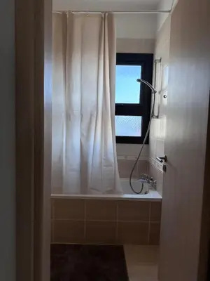 a bathroom with a shower curtain and a window at Seana Villa Protaras in Paralimni