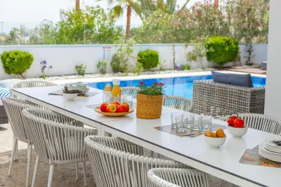 a table with fruit on it next to a pool at Fig Tree Bay Residences 4 in Protaras