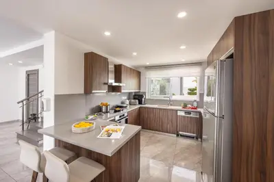 a kitchen with wooden cabinets and a counter top at Fig Tree Bay Residences 4 in Protaras