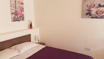a bedroom with a bed and two pictures on the wall at ZORBAS No 2 in Larnaka