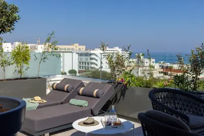 a patio with a couch and chairs on a balcony at Fig Tree Bay Residences 7 in Protaras