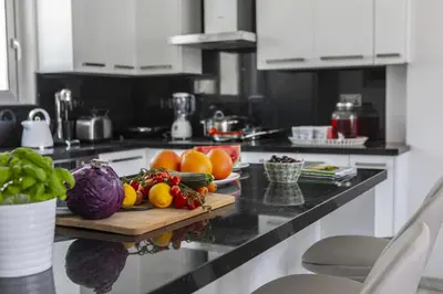 a kitchen counter with fruits and vegetables on a cutting board at Fig Tree Bay Residences 7 in Protaras