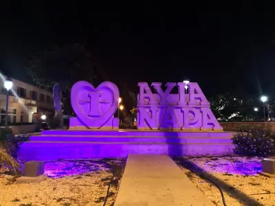 a monument with purple lighting in a park at night at Nissi Elena -Sunshine Apt in Ayia Napa