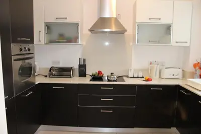 a kitchen with black cabinets and a stainless steel refrigerator at Elina villa near the sea in Protaras
