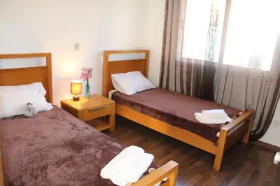 two beds in a small room with a window at Elina villa near the sea in Protaras
