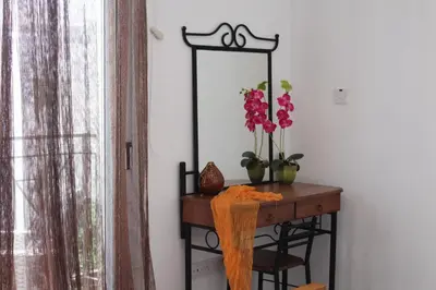 a dressing table with a mirror and flowers on it at Elina villa near the sea in Protaras