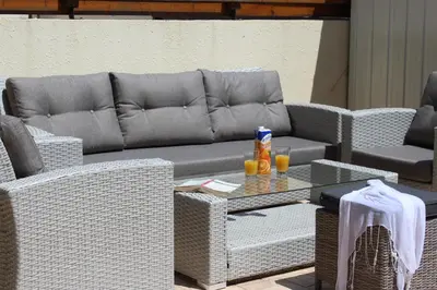 a wicker couch and chairs and a table with drinks on it at Elina villa near the sea in Protaras