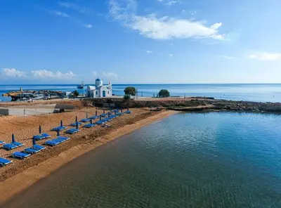 a beach with chairs and a pool of water at Elina villa near the sea in Protaras