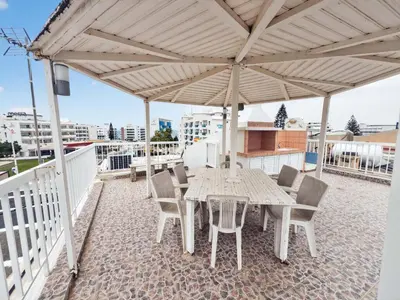 a wooden table and chairs under a canopy on a roof at Sofia's Seaview in Protaras