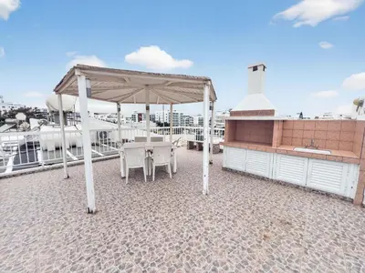 a patio with a table and a canopy on a roof at Sofia's Seaview in Protaras