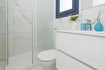 a white bathroom with a toilet and a shower at Villa Mey in Protaras