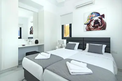 a bedroom with two beds and a painting of a dog at Villa Mey in Protaras