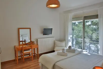 a bedroom with a bed and a desk and a window at Nestor Hillside House by TrulyCyprus in Moniatis