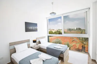 a bedroom with two beds and a large window at Blue Pearl Villas in Protaras