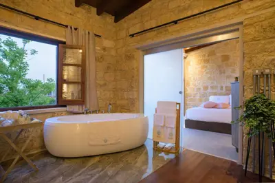 a bathroom with a large tub and a bedroom at Serenity Boutique House in Vouni