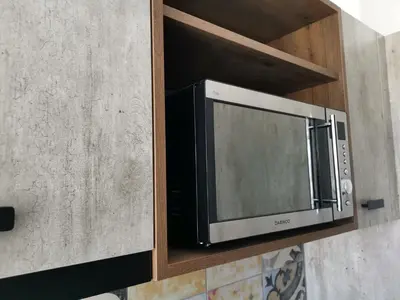 a microwave on a shelf in a kitchen at Shalos Studios in Ayia Napa