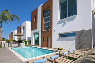 a swimming pool in the backyard of a house at Villa Carmen in Protaras