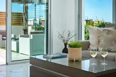 a living room with two glasses of wine on a table at Villa Carmen in Protaras