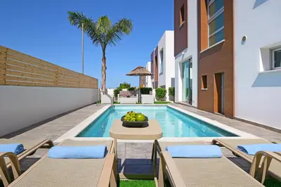 a villa with a swimming pool and a table and chairs at Villa Carmen in Protaras