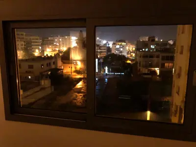 a view of a city at night from a window at Kennedy Deluxe Suites in Nicosia